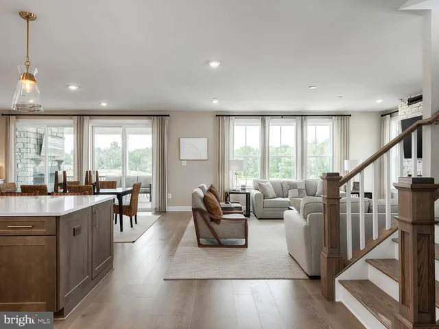 a living room with furniture wooden floor and a large window