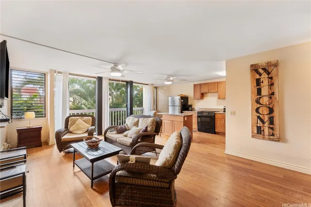 a living room with furniture floor to ceiling window and wooden floor