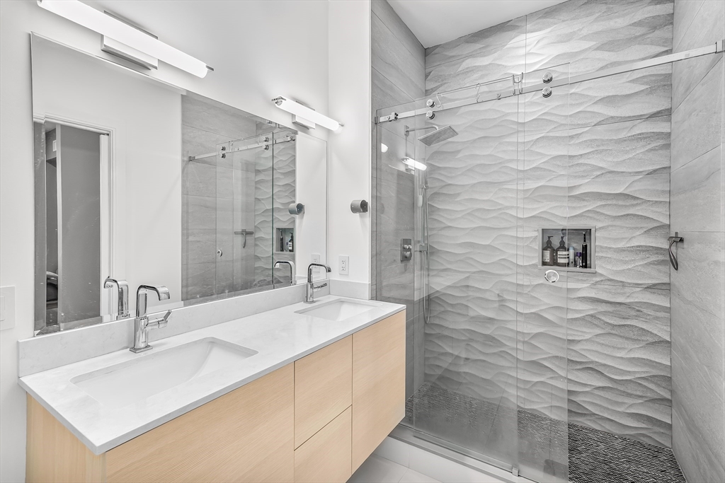 20 West Fifth Street, Unit 5E Boston, MA 02127 - Photo 18 of 42 a bathroom with a sink shower and a mirror