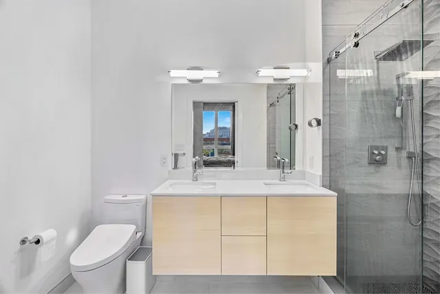 a bathroom with a sink a toilet and shower