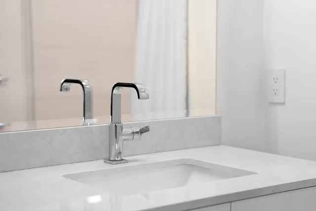 a bathroom with a granite countertop sink and a bathtub