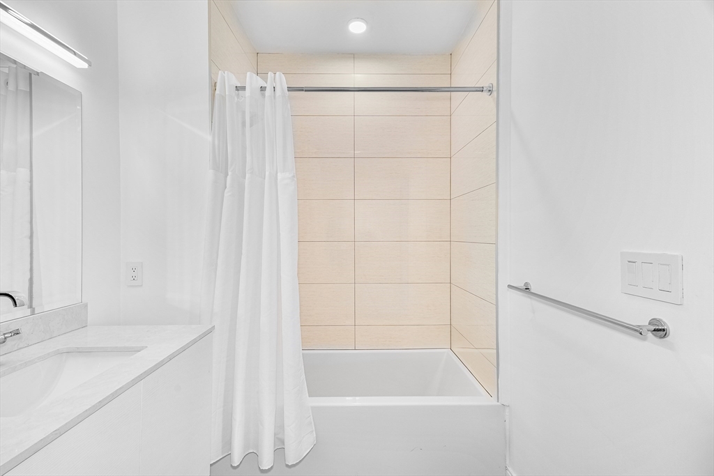 20 West Fifth Street, Unit 5E Boston, MA 02127 - Photo 22 of 42 a bathroom with a granite countertop sink and a bathtub