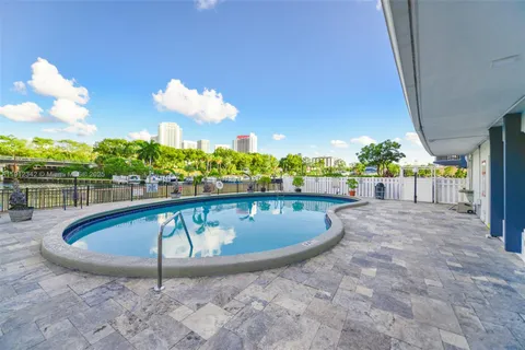 a view of a swimming pool with a patio and a yard
