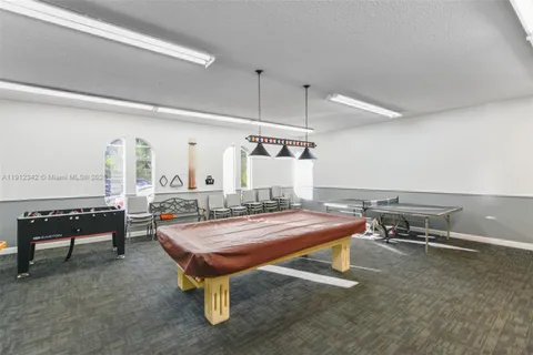 a room with furniture pool table and windows