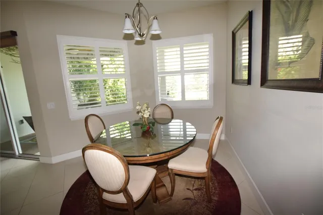 a dining room with furniture a chandelier and wooden floor