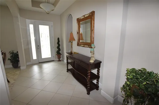 a hallway with a large mirror and a potted plant