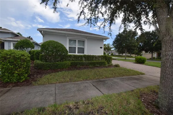 a front view of a house with a yard and trees