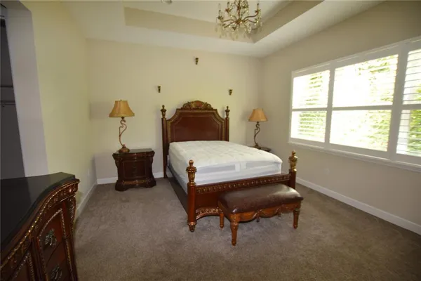 a bedroom with a bed and a chandelier