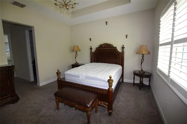 a bedroom with a bed and a chandelier
