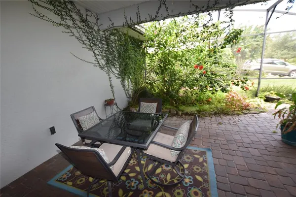 a patio with table and chairs and potted plants