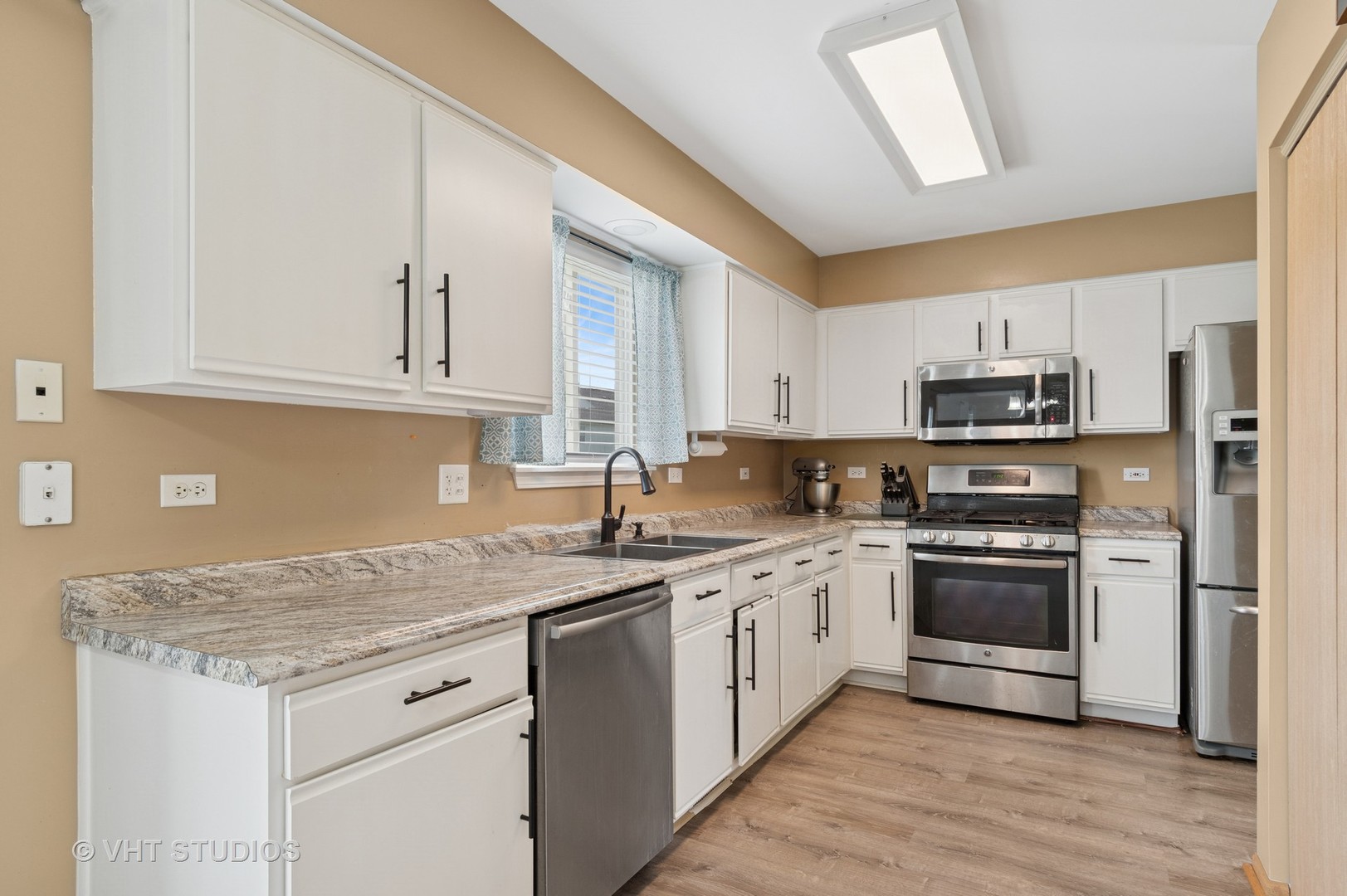 2477 Smithfield Court Aurora, IL 60503 - Photo 6 of 17 a kitchen with stainless steel appliances granite countertop a stove sink and cabinets
