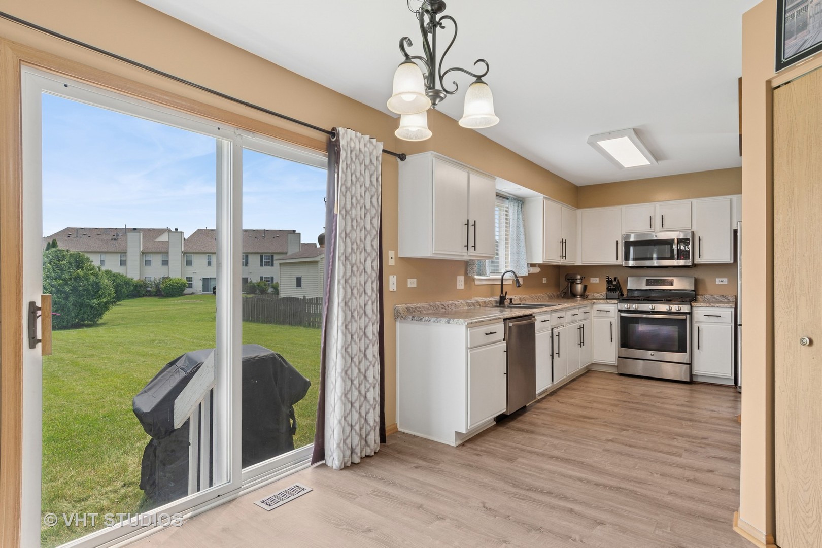 2477 Smithfield Court Aurora, IL 60503 - Photo 7 of 17 a kitchen with a refrigerator a stove top oven a sink dishwasher a kitchen island with wooden cabinets and floor