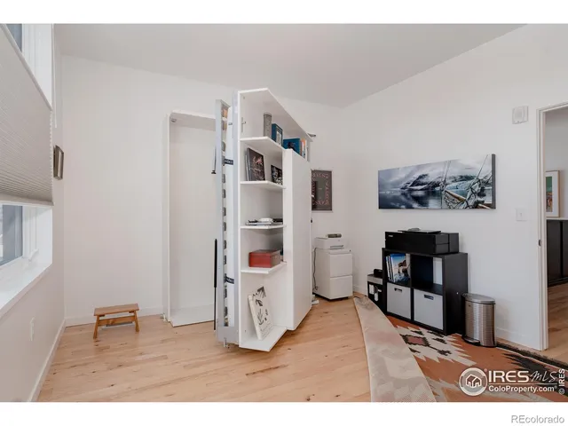 a bedroom with a bed and a painting on the wall