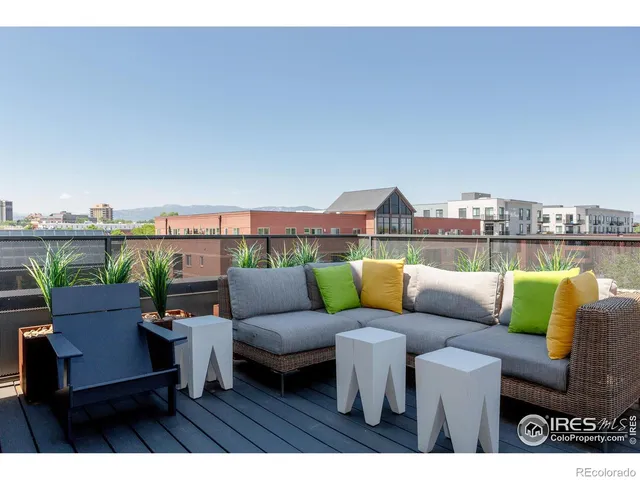 a balcony with wooden floor table and chairs
