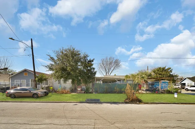 a view of a big house with a big yard and large trees
