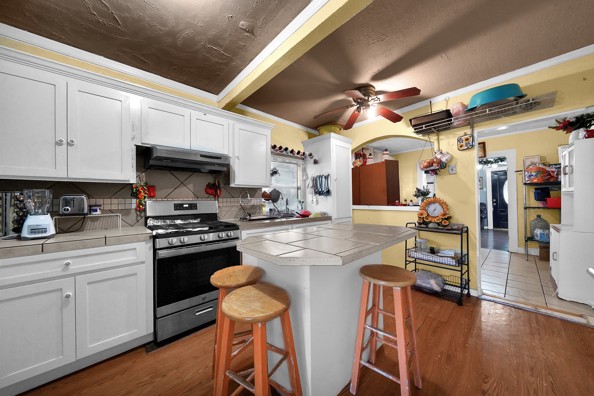 4811 Terry Street Houston, TX 77009 - Photo 17 of 30 a kitchen with stainless steel appliances granite countertop a stove top oven a sink a dining table and chairs with wooden floor
