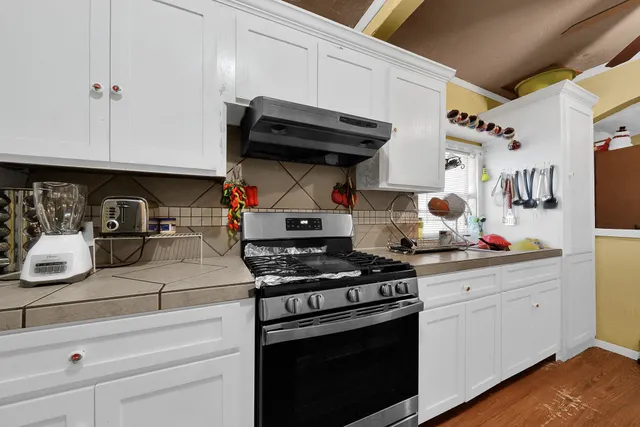 a kitchen with stainless steel appliances granite countertop a stove and cabinets