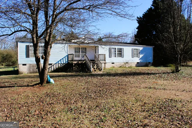 a view of a house with a yard covered in snow