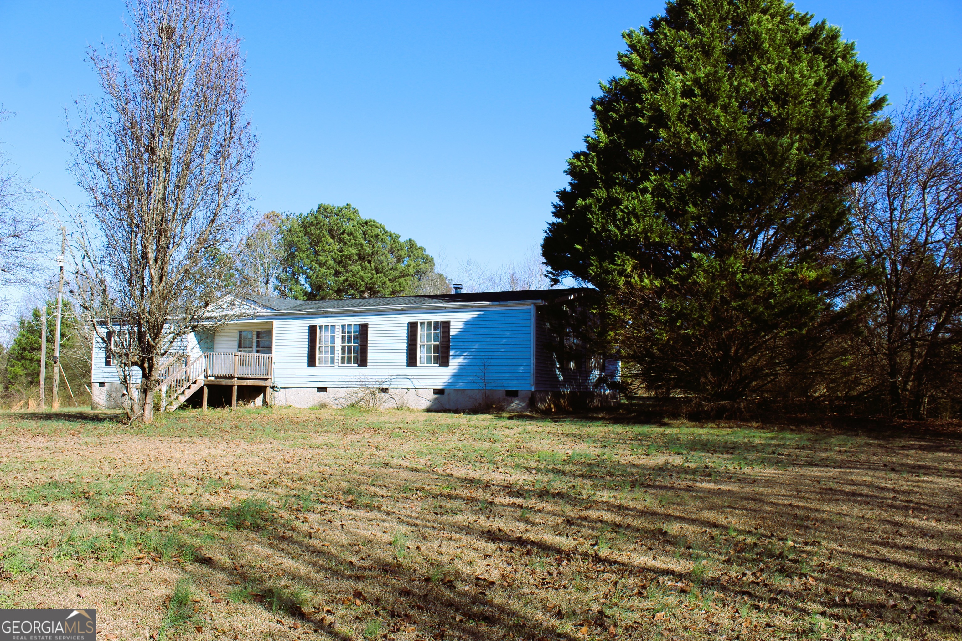 1691 A Rover Zetella Road Williamson, GA 30292 - Photo 2 of 24 a view of a yard in front of a house with large trees