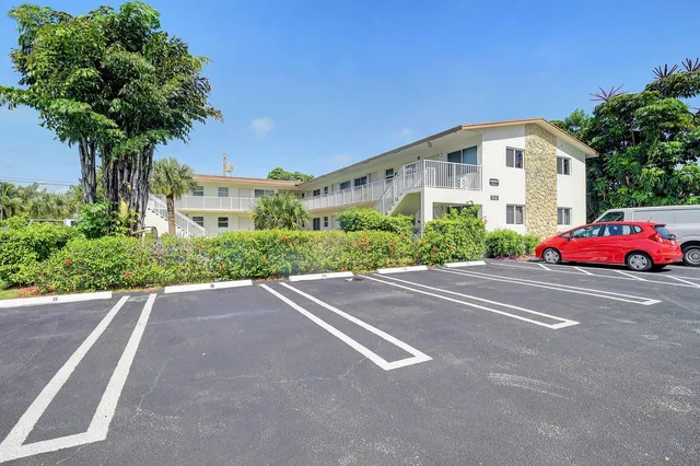 a front view of a house with trees and plants