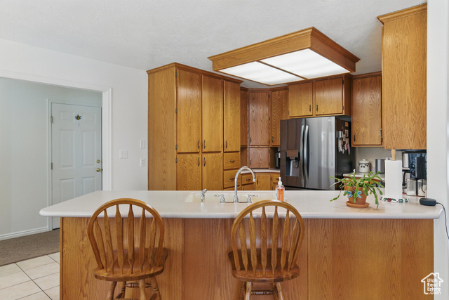 151 South Haulage Road Eureka, UT 84628 - Photo 12 of 36 Kitchen featuring a peninsula, brown cabinetry, stainless steel refrigerator with ice dispenser, and light countertops