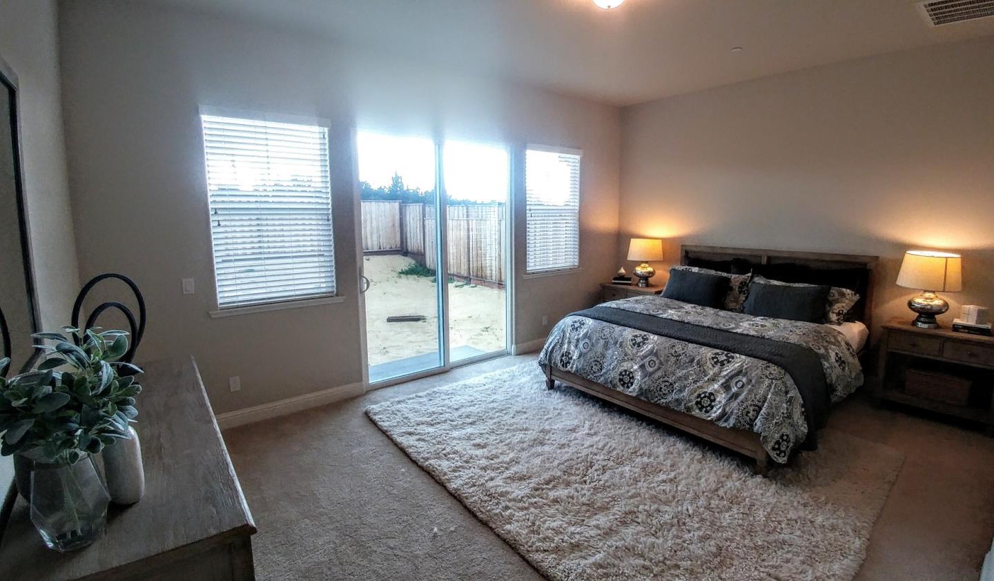 602 Braden Way Marina, CA 93933 - Photo 9 of 13 a bedroom with a bed a potted plant on dresser and a wooden floor