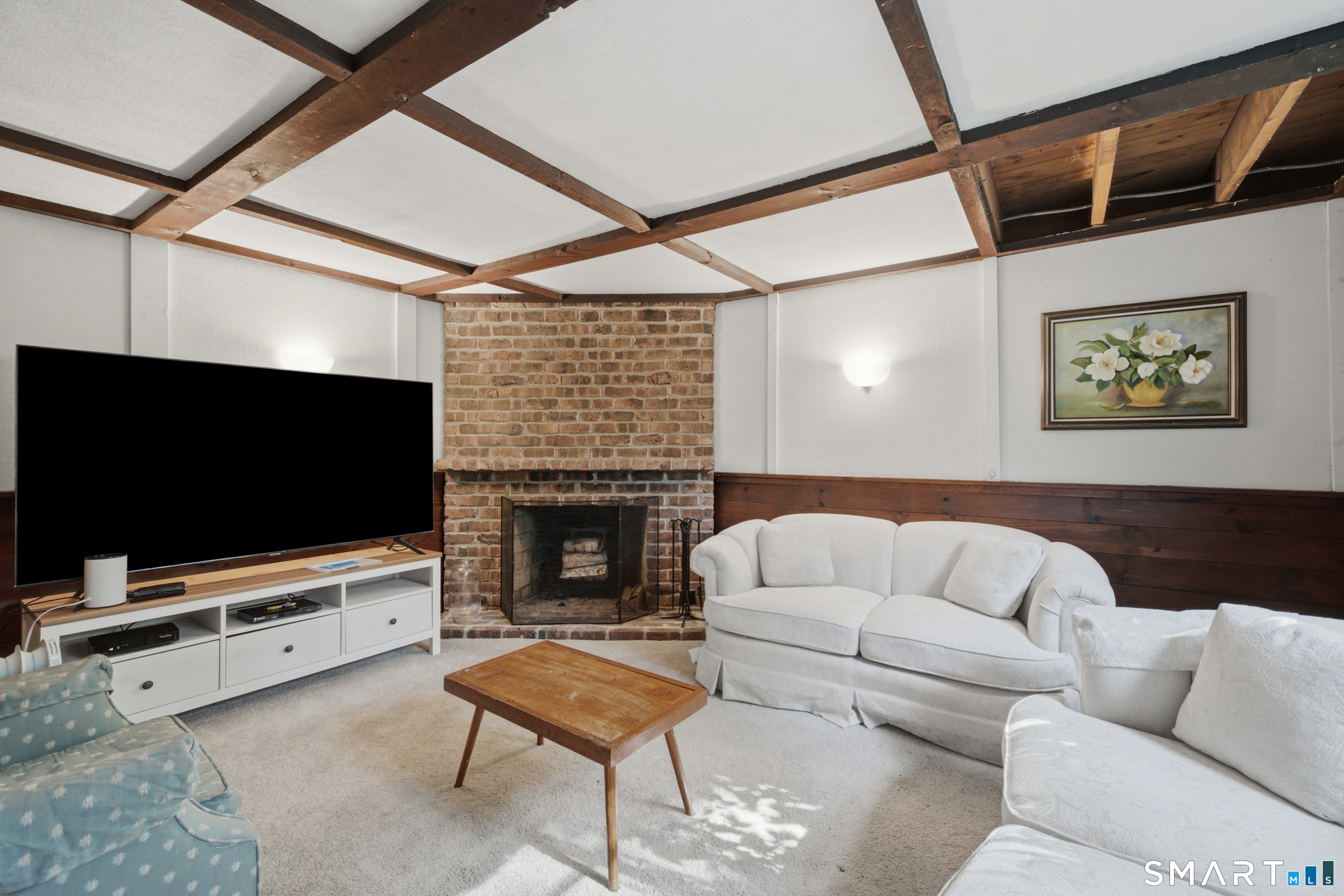 9 Stratford Road West Hartford, CT 06117 - Photo 33 of 40 The finished lower-level family room features a cozy fireplace, creating a comfortable space for relaxing, entertaining, or movie nights