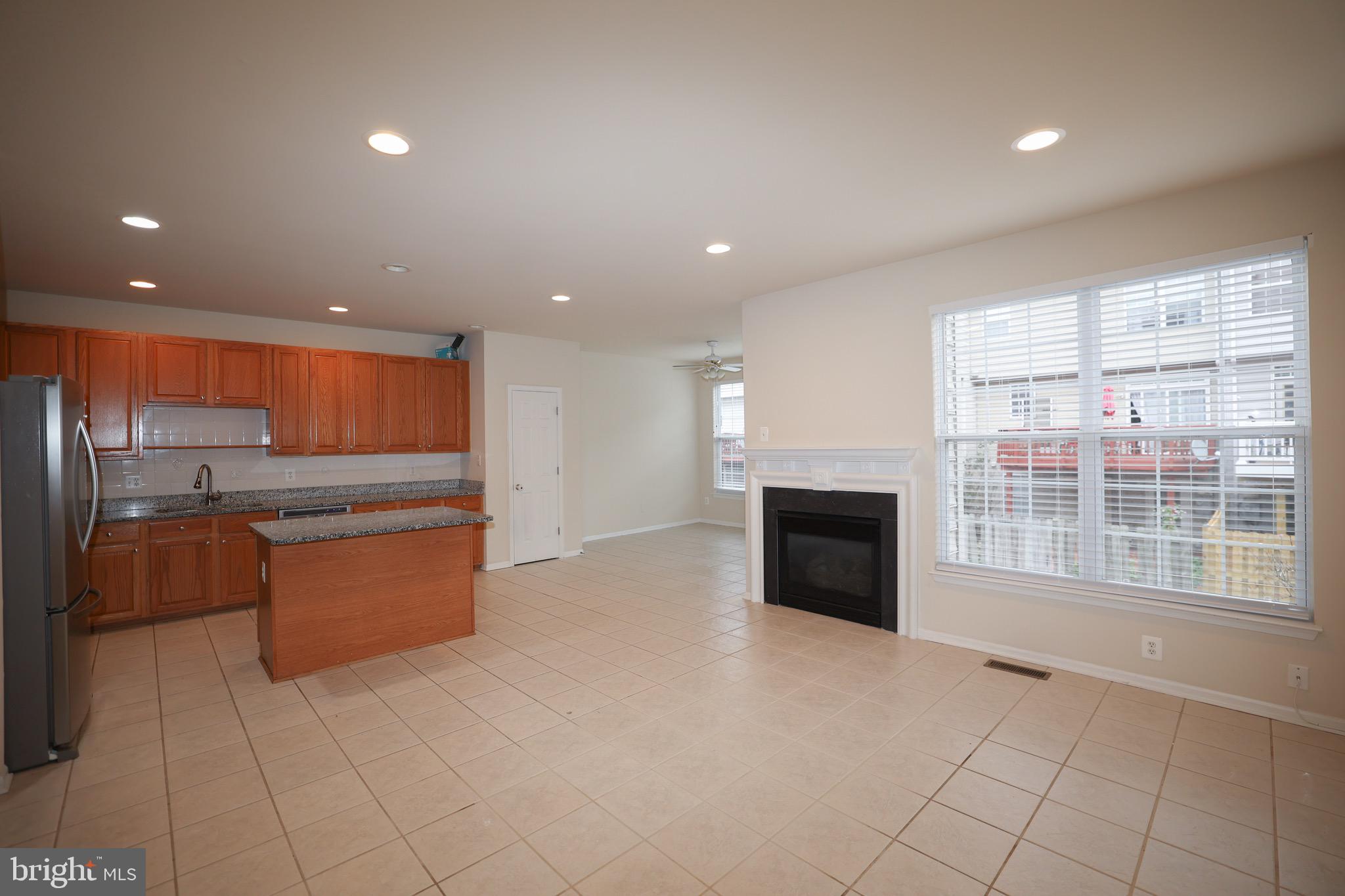 20840 Miranda Falls Square Sterling, VA 20165 - Photo 4 of 17 a large kitchen with stainless steel appliances a large counter top and a fireplace