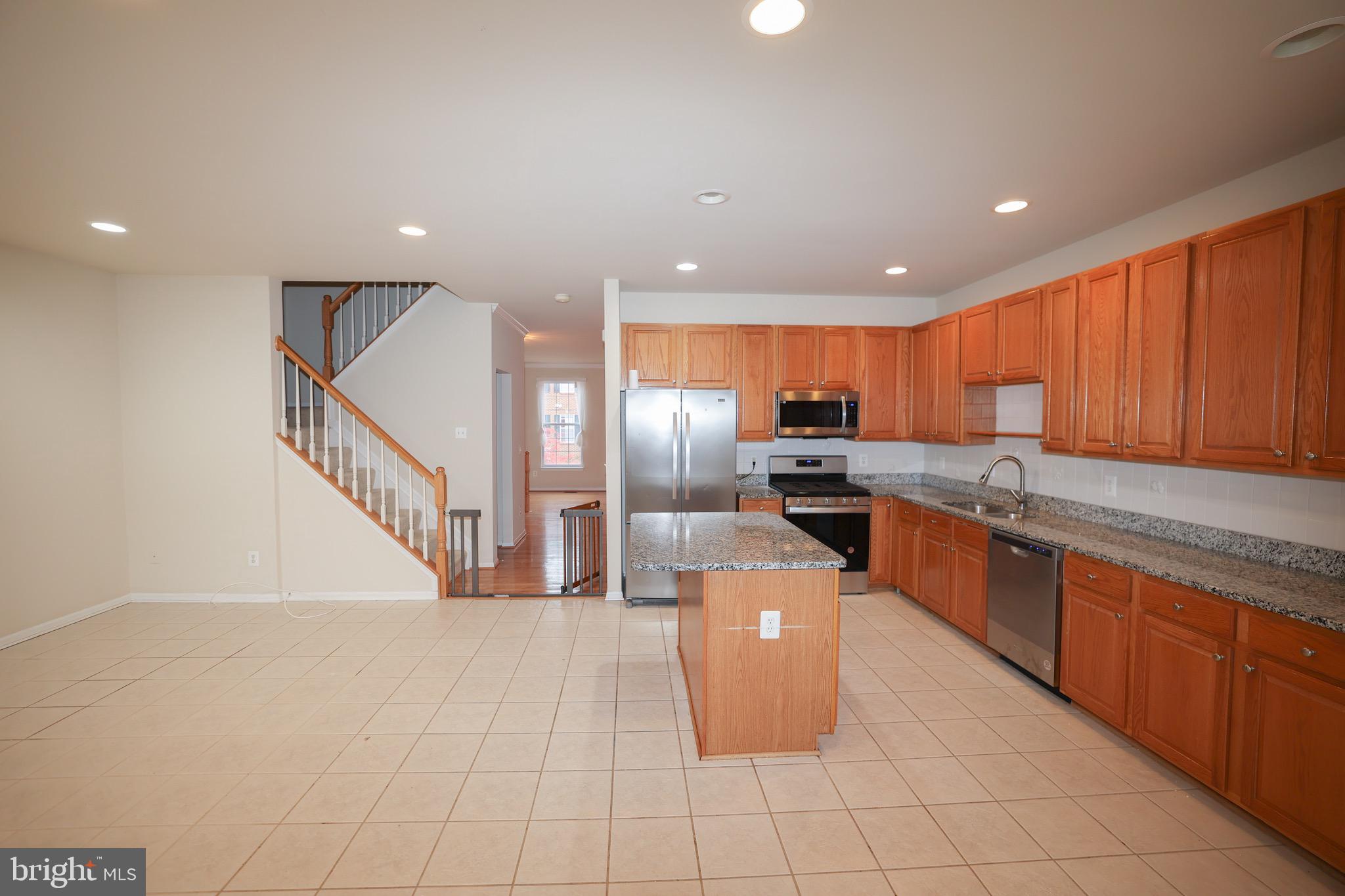 20840 Miranda Falls Square Sterling, VA 20165 - Photo 5 of 17 a kitchen with stainless steel appliances granite countertop a refrigerator a sink a stove a microwave and island