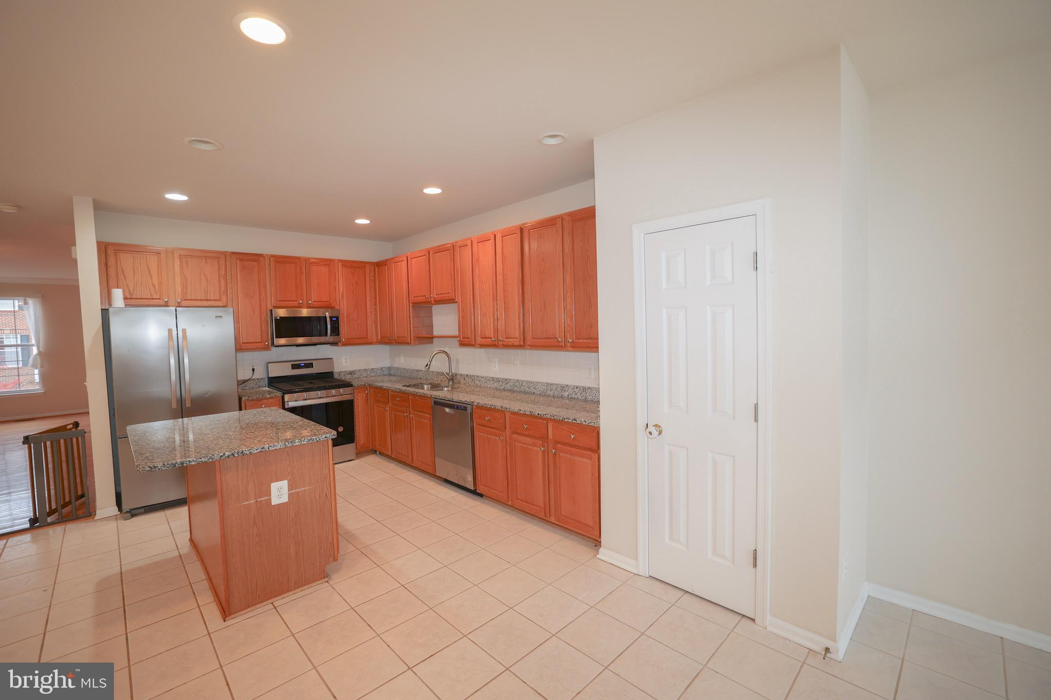 20840 Miranda Falls Square Sterling, VA 20165 - Photo 6 of 17 a kitchen with stainless steel appliances granite countertop a refrigerator and a sink