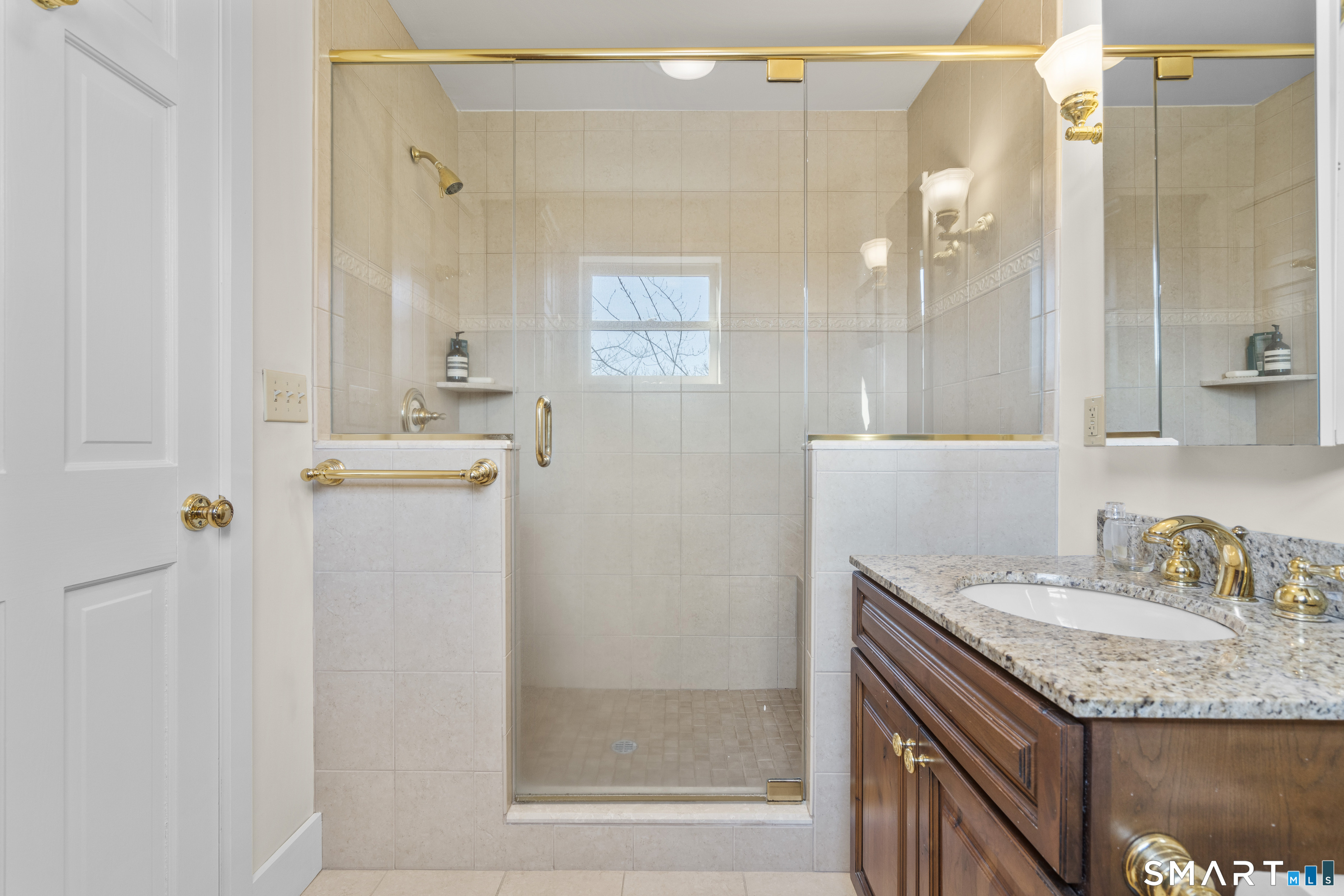 55-69 Sawmill Road Branford, CT 06405 - Photo 26 of 40 a bathroom with a granite countertop sink a mirror and a shower