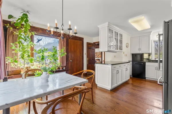 a kitchen with stainless steel appliances granite countertop a stove refrigerator and a wooden floor