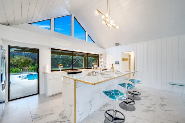 a kitchen with a sink and chairs