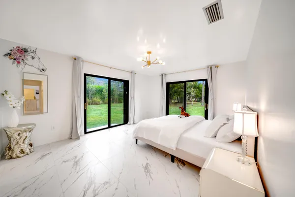 a large bed sitting in a bedroom next to a window