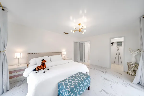 a bed room with a bed and a chandelier