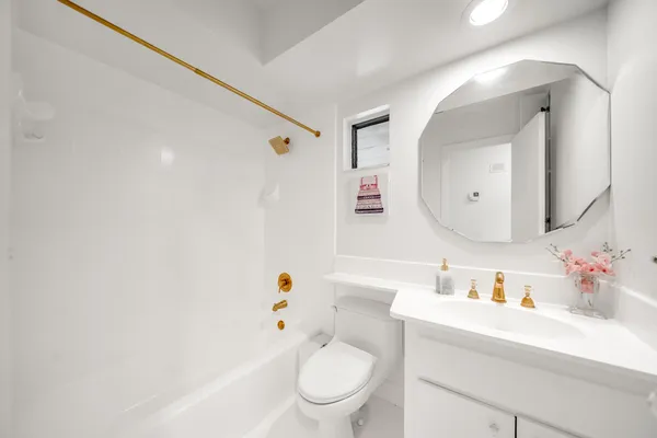 a bathroom with a sink a toilet and a mirror