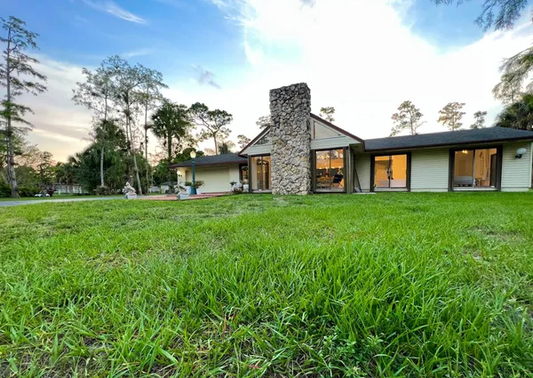 a front view of house with a garden