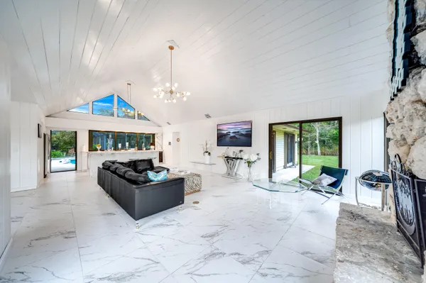 a living room with furniture a fireplace and a chandelier
