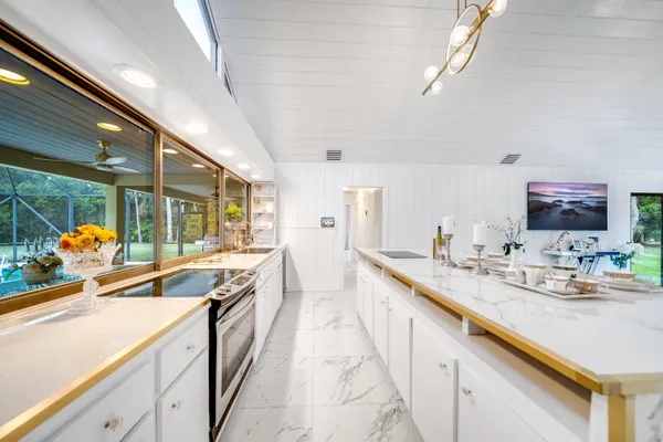 a kitchen with stainless steel appliances granite countertop a sink and dishwasher a oven with white cabinets