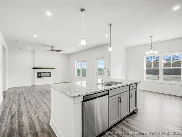 a kitchen with a sink window and wooden floor