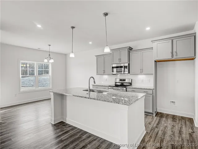 a kitchen with kitchen island a sink appliances and cabinets