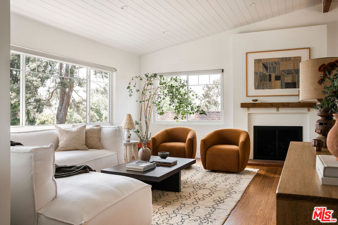 258 Redwood Drive Pasadena, CA 91105 - Photo 4 of 34 a living room with furniture a large window and a fireplace