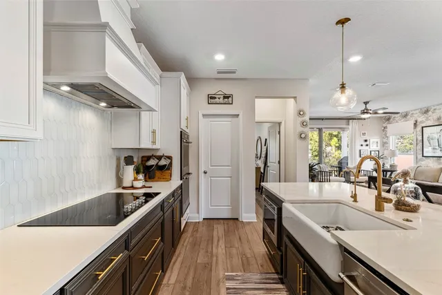a kitchen with kitchen island a counter top space a sink stainless steel appliances and cabinets