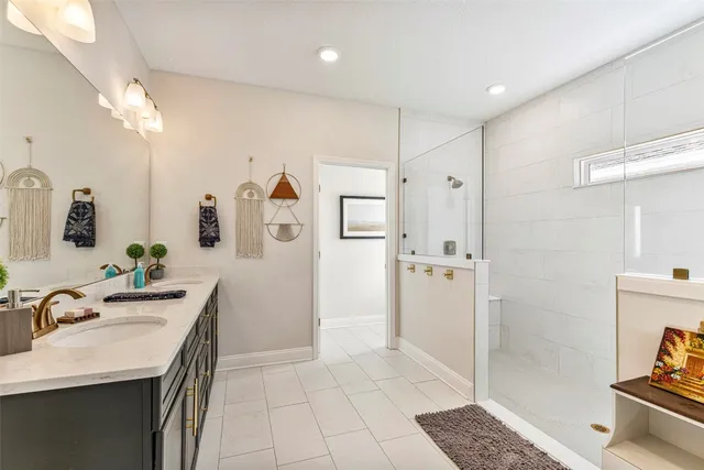 a spacious bathroom with a granite countertop sink a mirror and shower
