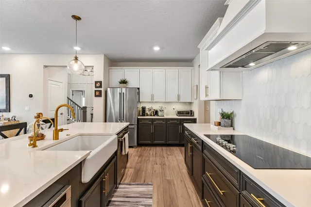 a kitchen with stainless steel appliances granite countertop a sink refrigerator and cabinets
