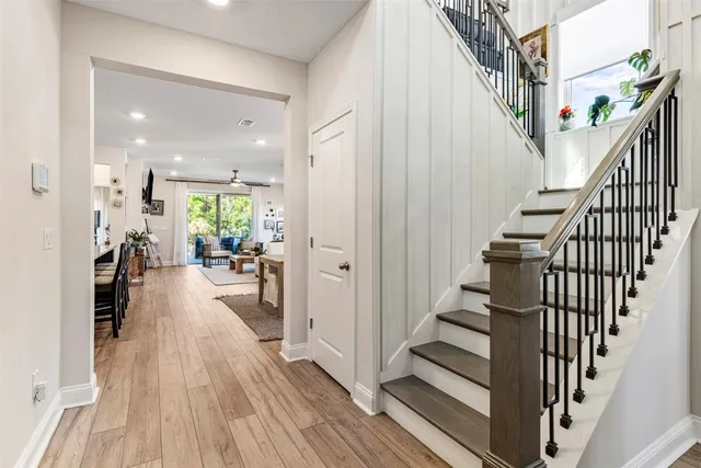 a view of a hallway with wooden floor and stairs