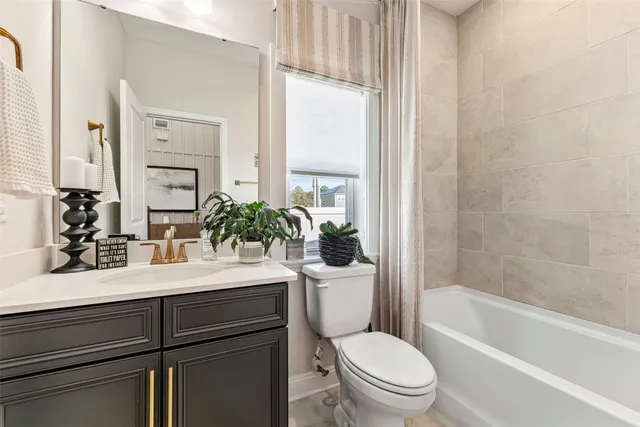 a bathroom with a sink a toilet a mirror and shower