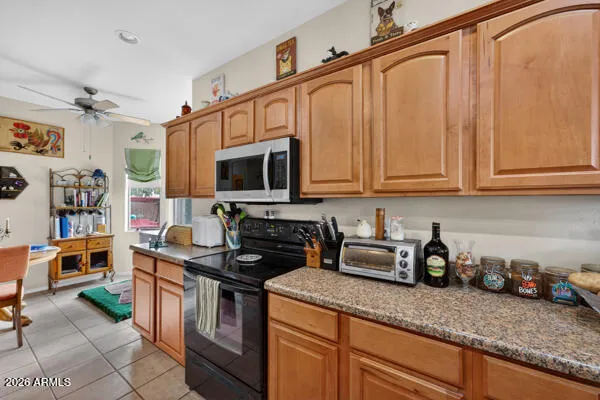 a kitchen with granite countertop a table chairs stove and cabinets