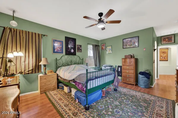 a bedroom with a bed a chandelier and dresser