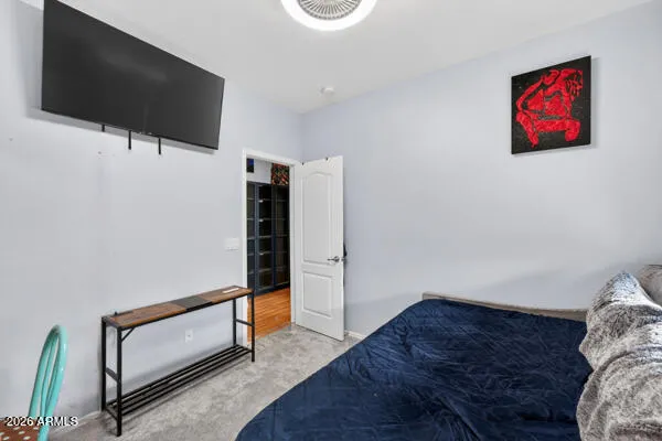 a bedroom with a bed a lamp and large window